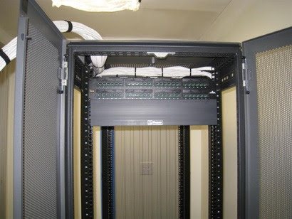 Enclosed network cabinet: Lockable cabinet with patch panels and overhead cable entry.